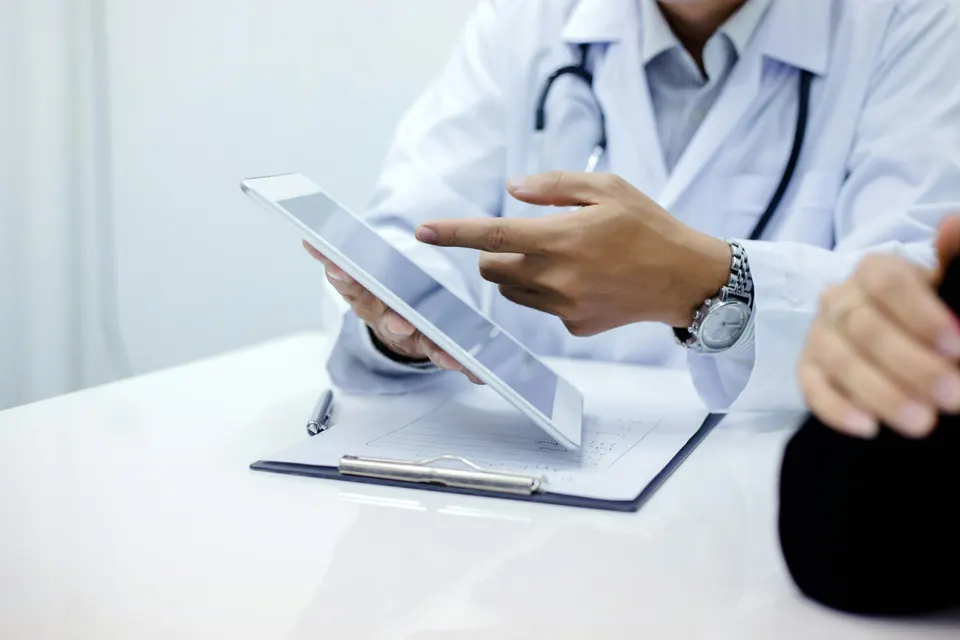 A clinician pointing to information on a tablet