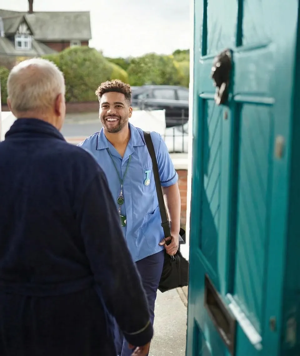 A home-care nurse greeting an older man at his front door